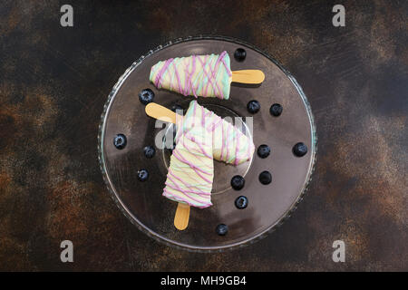 Süße Bonbons mit Heidelbeere in Form von Eis auf dunklem Hintergrund Stockfoto