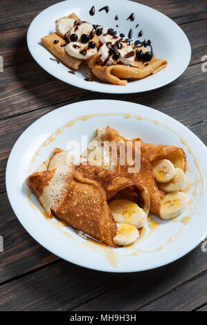 Pfannkuchen mit Schokolade und Banane auf einer hölzernen Hintergrund. Stockfoto