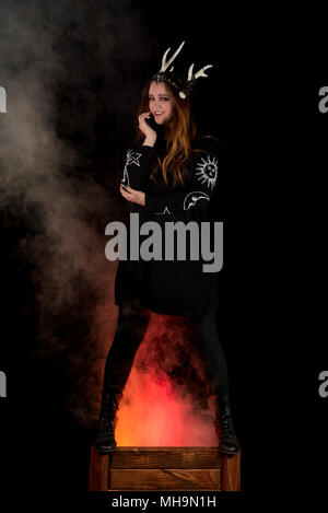 Die Schwestern der Coven kommen zusammen, um einander durch Zaubersprüche zu schützen. Weibliche Modell auf schwarzem Hintergrund. Handgefertigten Schmuck und Kopf Stücke. Stockfoto