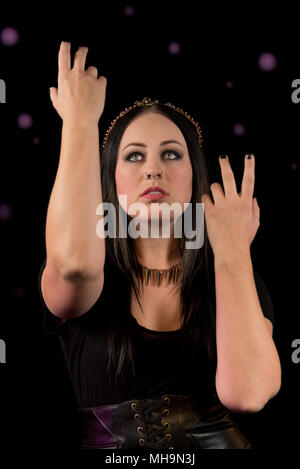 Die Schwestern der Coven kommen zusammen, um einander durch Zaubersprüche zu schützen. Weibliche Modell auf schwarzem Hintergrund. Handgefertigten Schmuck und Kopf Stücke. Stockfoto