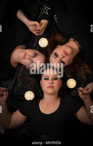 Die Schwestern der Coven kommen zusammen, um einander durch Zaubersprüche zu schützen. Weibliche Modell auf schwarzem Hintergrund. Handgefertigten Schmuck und Kopf Stücke. Stockfoto