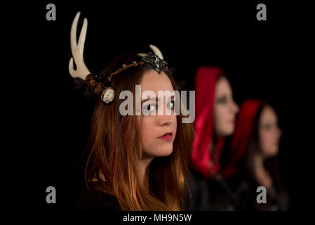 Die Schwestern der Coven kommen zusammen, um einander durch Zaubersprüche zu schützen. Weibliche Modell auf schwarzem Hintergrund. Handgefertigten Schmuck und Kopf Stücke. Stockfoto