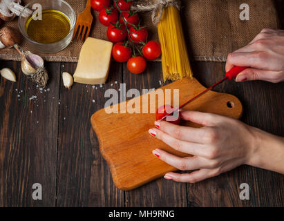 Nahaufnahme der Hand schneiden Tomaten für Spaghetti. Stockfoto