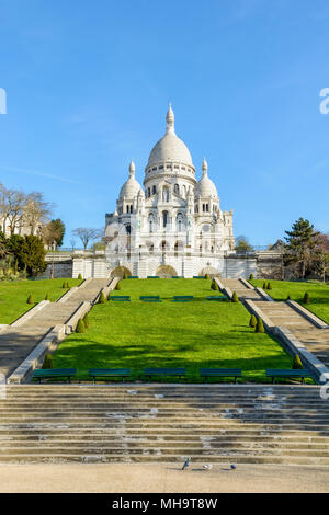 Vorderansicht der Basilika des Heiligen Herzen von Paris an der Spitze des Montmartre Hill von der Unterseite der Treppen in der Louise Michel Park. Stockfoto