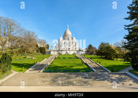 Vorderansicht der Basilika des Heiligen Herzen von Paris an der Spitze des Montmartre Hill von der Unterseite der Treppen in der Louise Michel Park. Stockfoto