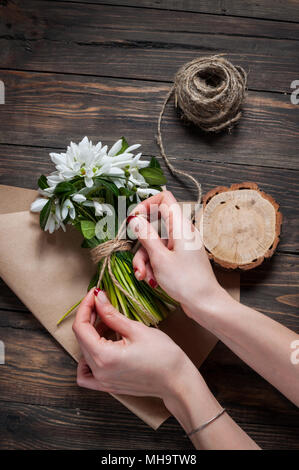 Weibliche Floristen binden bis frisches Bouquet mit Garn Stockfoto