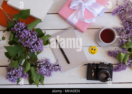 Auf dem weißen Tisch Flieder, Notebook, Kamera Stockfoto