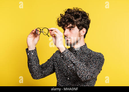 Studio Porträt eines jungen Mannes auf einem gelben Hintergrund. Stockfoto