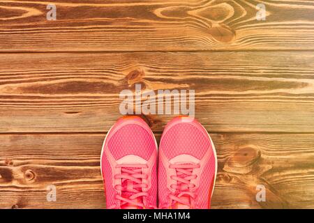 Rosa Sneakers auf Holz- Textur Stockfoto