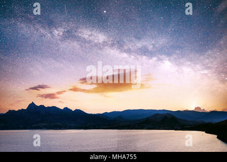 Herrliche panorama auf den Sonnenaufgang über dem Meer. Lebendige Nachthimmel mit Sterne und Nebel und Galaxien. Deep Sky astrophoto Stockfoto