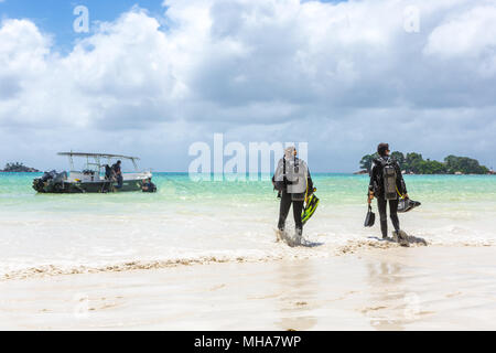 Taucher zu Fuß am Strand auf den Seychellen. Stockfoto