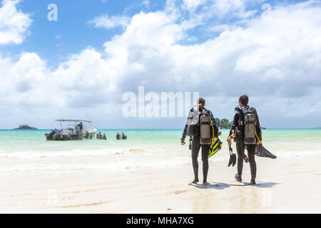 Taucher zu Fuß am Strand auf den Seychellen. Stockfoto
