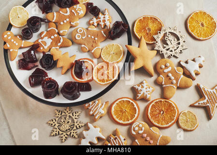 Weihnachten Lebkuchen cookies und getrocknete orange und Gewürzen auf weißer Tisch. Pastellfarben, Marmelade in Rollen auf einer Platte Stockfoto