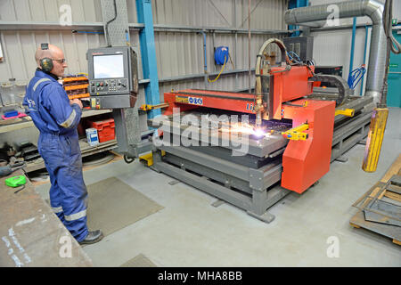 Mann bei der Arbeit auf einer metallenen Plasmaschneidemaschine in einer Werkstatt Stockfoto