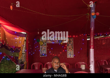 Man spricht über sein Handy in einem Restaurant, Sonepur, Indien. Stockfoto