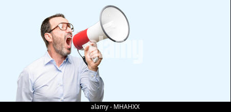 Mittleres alter Mann mit Brille kommuniziert schreien laut Holding ein Megaphon, mit dem Ausdruck Erfolg und positive Konzept, Idee, Marketing oder Vertrieb Stockfoto