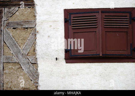 Eine auffallende Holz- Fenster Luke in eine Scheune Wand mit einem abblätternden Putz Layer. Stockfoto