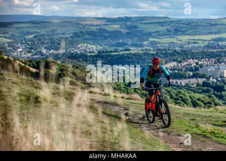 Ein Mann reitet einen elektrischen Pedal e-Bike in der Nähe der Stadt Halifax im Norden von England zu unterstützen. Stockfoto