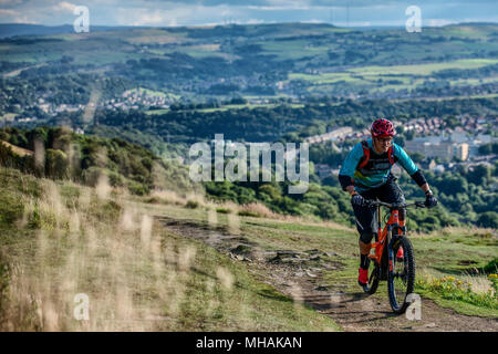 Ein Mann reitet einen elektrischen Pedal e-Bike in der Nähe der Stadt Halifax im Norden von England zu unterstützen. Stockfoto