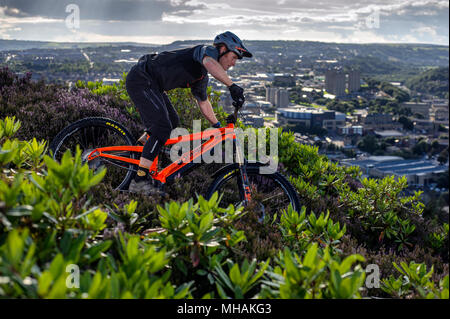 Ein Mann reitet einen elektrischen Pedal e-Bike in der Nähe der Stadt Halifax im Norden von England zu unterstützen. Stockfoto