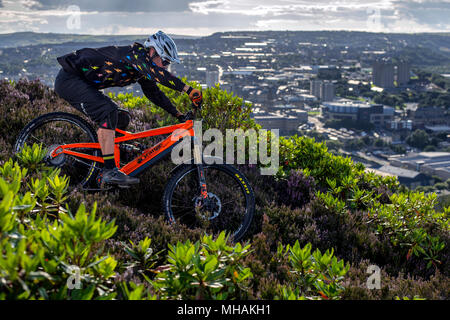 Ein Mann reitet einen elektrischen Pedal unterstützen e-Bike mit Blick auf die Stadt von Halifax in Nordengland. Stockfoto