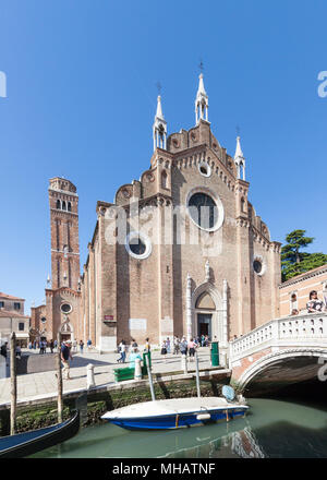 Die Basilika Santa Maria Gloriosa dei Frari, Campo dei Frari, San Polo, Venedig, Venetien, Italien mit Reflexionen und ein Boot in den Kanal. Touristen in Cam Stockfoto