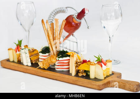 Käseplatte: Roquefort mit blauen Schimmel, Cheddar, geräucherter Käse, Mozzarella auf einem Holzbrett. Mit Brot sticks eingerichtet Stockfoto