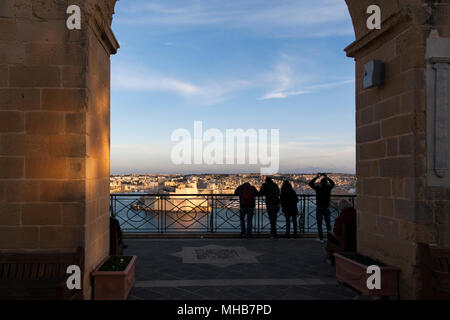 Malteser und Besucher versammeln sich bei Sonnenuntergang in den Tivoli-Gärten, um die Aussicht zu bewundern und einen ruhigen Moment zu finden. Valletta, Malta Stockfoto