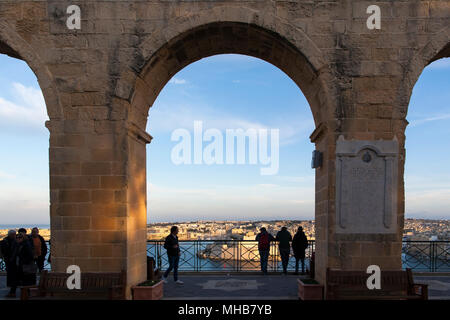 Malteser und Besucher versammeln sich bei Sonnenuntergang in den Tivoli-Gärten, um die Aussicht zu bewundern und einen ruhigen Moment zu finden. Valletta, Malta Stockfoto