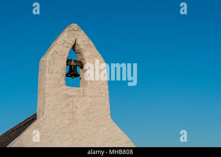 Kleiner Glockenturm mit einer Glocke von einem Waliser land Kapelle, gegen den tiefblauen Himmel Stockfoto