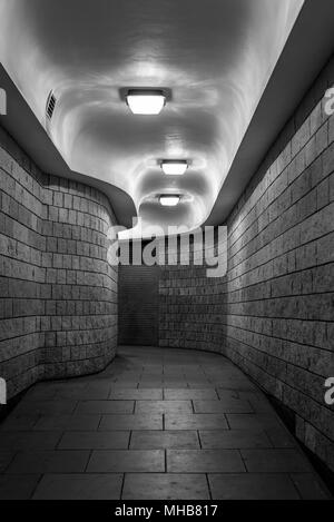 Eine gewundene Fußgängertunnel (U-Bahn) in der City von London, in der Nacht - Schwarz und Weiß Stockfoto