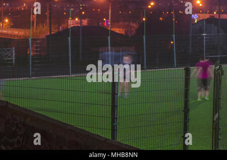 Ein Fußballspiel in der Nacht in der Stadt. verschwommene Bewegung Stockfoto