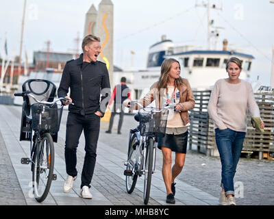 Schwedische Familie zu Fuß durch Strandvägen Straße mit ihren Bikes, Stockholm, Schweden Stockfoto