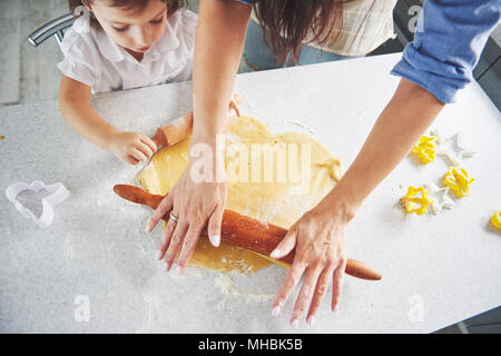 Glückliche Familie Vorbereitung essen Konzept. Familie kochen Weihnachtsplätzchen. Hände von Mutter und Tochter bereitet den Teig auf dem Tisch. Glückliche Familie, um Cookies zu Hause Stockfoto