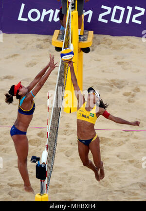 Olympische Spiele in London 2012: Women's Beach Volleyball Brasilien Juliana Silva tippt den Ball über das Netz als Chinas Chen Xue versucht zu blockieren. Brasilien besiegte China die Bronzemedaille zu gewinnen. Stockfoto