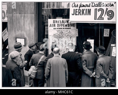 WW2 Britain Air Offensive Ein britischer Flieger ist unter einer Gruppe von Zivilisten, die sich um das Fenster eines Ladens in Holborn, London, gedrängt haben, um sich eine Karte anzusehen, die zeigt, wie die RAF während des Zweiten Weltkriegs 1940 auf Deutschland zurückschlägt Stockfoto