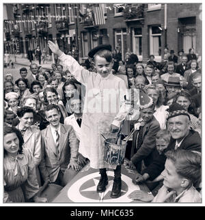 HITLER PARODIE am Ende des Zweiten Weltkrieges. Holländische Straße Festlichkeiten nach der Befreiung in der Hauptstadt der Niederlande Amsterdam.. Little Boy gekleidet wie ein Künstler Maler Adolf Hitler die Heil Hitler salute in Parodie gibt Juni 28, 1945 WW2 ist zu Ende. Stockfoto