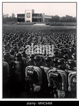 Ns-Waffen-SS-Truppen in polierten Helme in präzise serried Rank an Salute stehen während eines deutschen Nazi Kundgebung vor dem Zweiten Weltkrieg Nürnberg 1930 Stockfoto