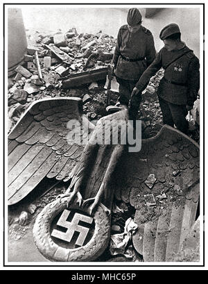 Das NS-Reichskanzleramt Berlin Deutschland DER FALL BERLINS UND DAS DRITTE REICH 1945 in Europa endet. Russische Soldaten nach dem Fall Berlins sehen einen zerrissenen deutschen Nazi-Adler mit Hakenkreuz-Emblem, der in den Ruinen des ehemaligen Sitz der Nazi-deutschen Macht liegt, das Reichskanzleramt Berlin Deutschland 'der Fall des Dritten Reiches' am 8. Mai 1945 Stockfoto