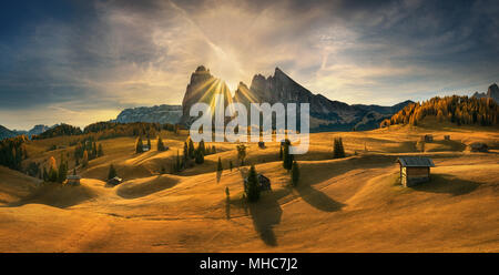 Ansicht der traditionellen Holz- Mountain Chalets an der malerischen Seiser Alm mit Langkofel Berg bei Sonnenaufgang, Dolomiten, Südtirol, Italien Stockfoto