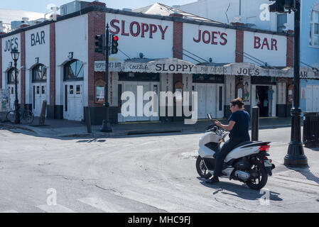 Key West, Florida - 29. April 2018. Frau auf dem Motorrad außerhalb der berühmten Sloppy Joe's Bar in Key West, in der Nähe der ursprünglichen Speicherort, wo Hemmingway uns Stockfoto