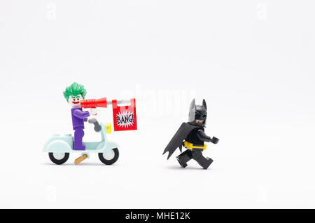 Mini Abbildung von joker reiten Roller mit bang Pistole jagt Batman. Lego Minifiguren sind von der Lego Gruppe hergestellt. Stockfoto