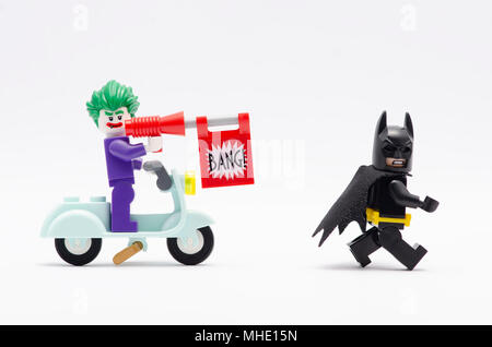 Mini Abbildung von joker reiten Roller mit bang Pistole jagt Batman. Lego Minifiguren sind von der Lego Gruppe hergestellt. Stockfoto