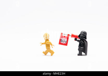 Mini Figur des Darth Vader mit bang Pistole schiessen auf c3po. Lego Minifiguren sind von der Lego Gruppe hergestellt. Stockfoto