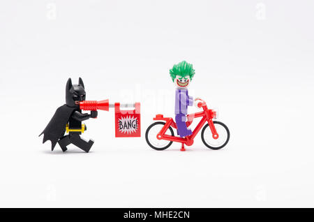 Mini Abbildung von Batman mit bang Pistole jagen Joker auf einem Fahrrad. Lego Minifiguren sind von der Lego Gruppe hergestellt. Stockfoto