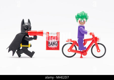 Mini Abbildung von Batman mit bang Pistole jagen Joker auf einem Fahrrad. Lego Minifiguren sind von der Lego Gruppe hergestellt. Stockfoto