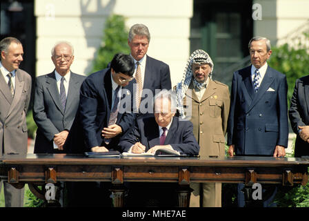 Washington, DC. 9-13-1993 Präsident William Jefferson Clinton hosts Die Palestintin Friedensabkommen Vertrag unterzeichnen auf der South Lawn des Weißen Hauses. Premierminister Yitzhak Rabin Israels und der Palästinensischen Befreiungsorganisation Vorsitzender, Yasser Arafat, Hände schütteln in einer öffentlichen Zeremonie im Weißen Haus nach der Unterzeichnung einer Vereinbarung, die begrenzte Autonomie nach Palästina gewährt und legte den Grundstein für die künftige Friedensgespräche. William Jefferson "Bill" Clinton ist ein US-amerikanischer Politiker, von 1993 bis 2001 als der 42. Präsident der Vereinigten Staaten gedient. Im Alter von 46 Jahren eröffnet wurde, war er der dritte Stockfoto