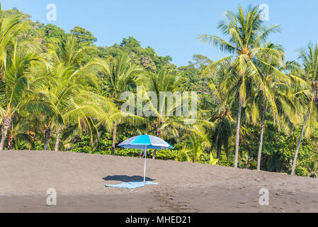 Sonnenschirm und Handtuch an der Playa Hermosa de Costa Rica - Pazifikküste Stockfoto