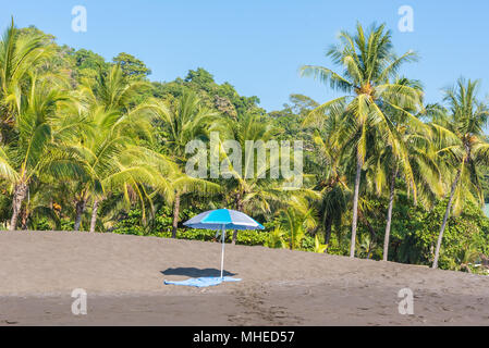 Sonnenschirm und Handtuch an der Playa Hermosa de Costa Rica - Pazifikküste Stockfoto