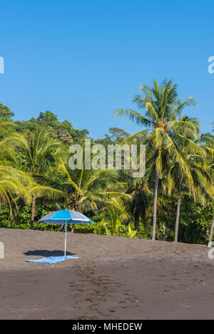 Sonnenschirm und Handtuch an der Playa Hermosa de Costa Rica - Pazifikküste Stockfoto